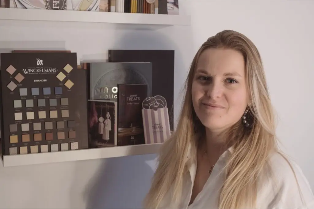 ortrait d’Alice Vaure devant une étagère d’échantillons, architecte d’intérieur à Lille