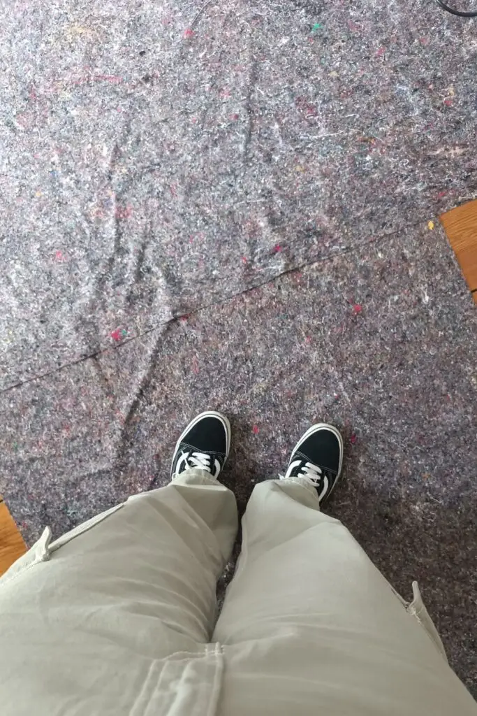 Sol protégé sur un chantier de rénovation vu du dessus, avec les pieds d’Alice Vadurel