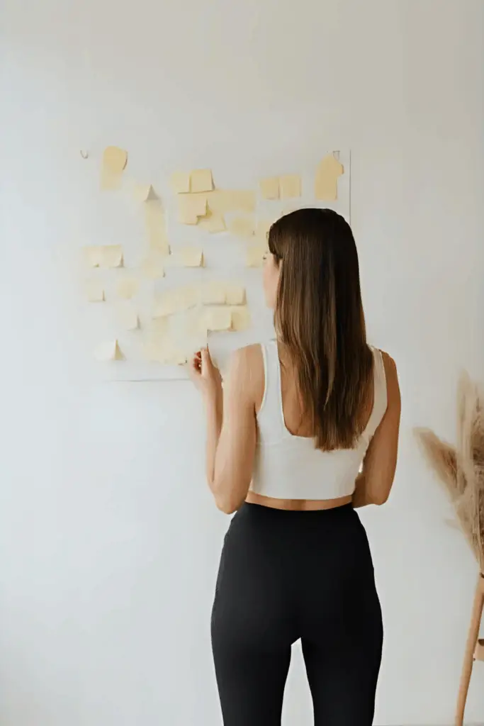 Architecte d’intérieur en train de planifier son activité sur un mur de post-its.