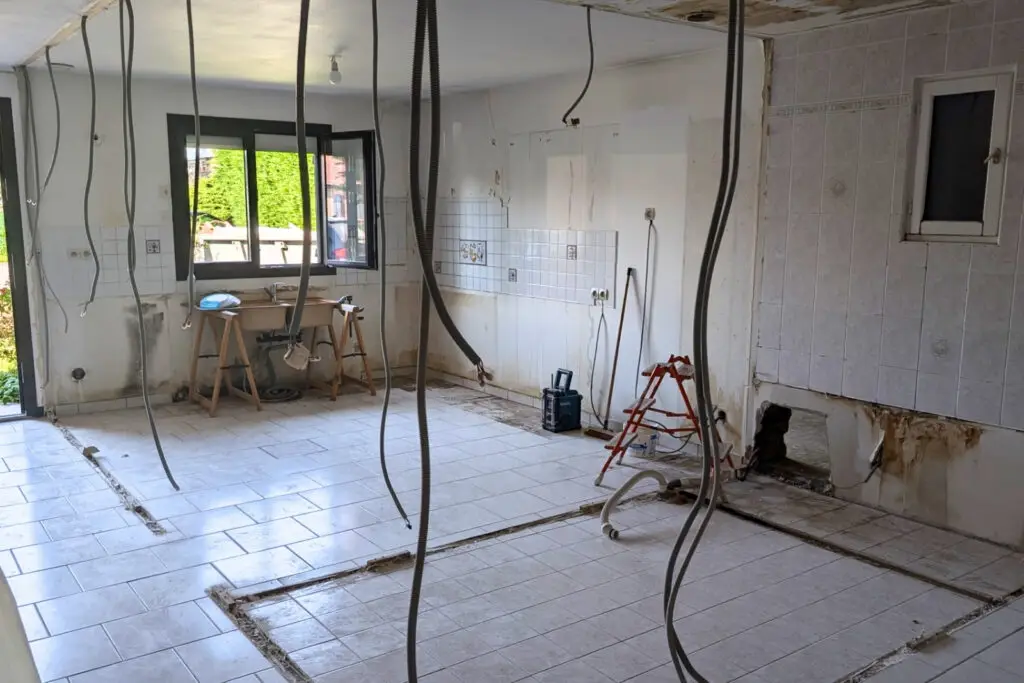 Vue du chantier en cours avec murs ouverts et sols carrelés