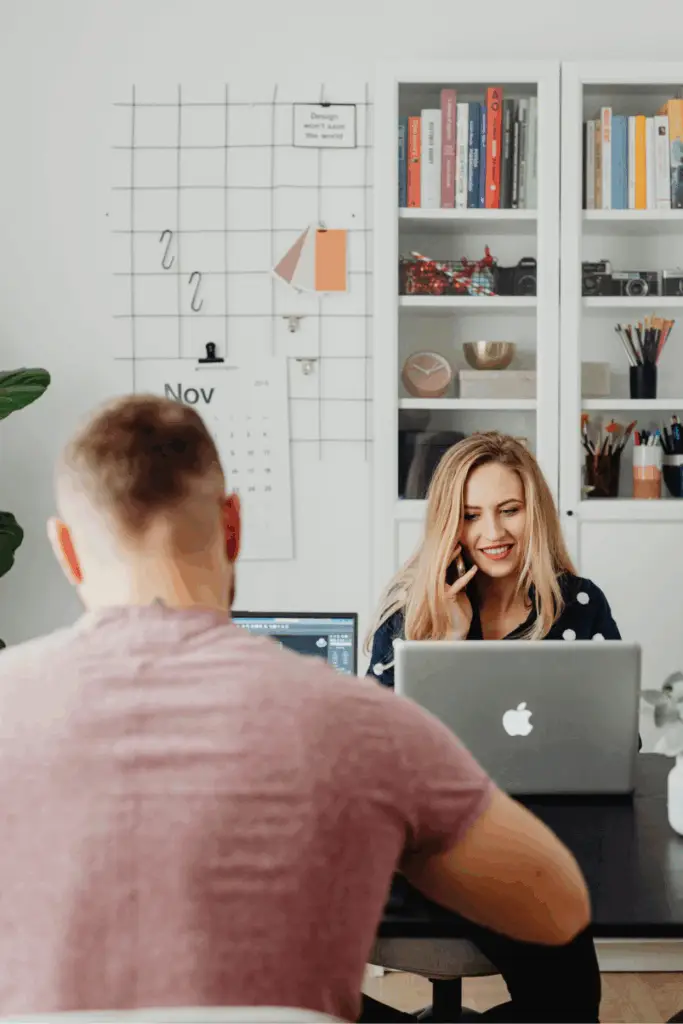 Collaboratrice au téléphone souriante, en train de travailler en équipe
