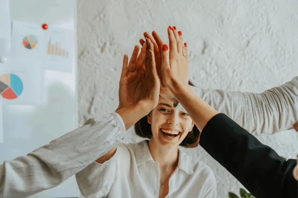 Femmes souriantes se tapant dans la main dans un moment de solidarité