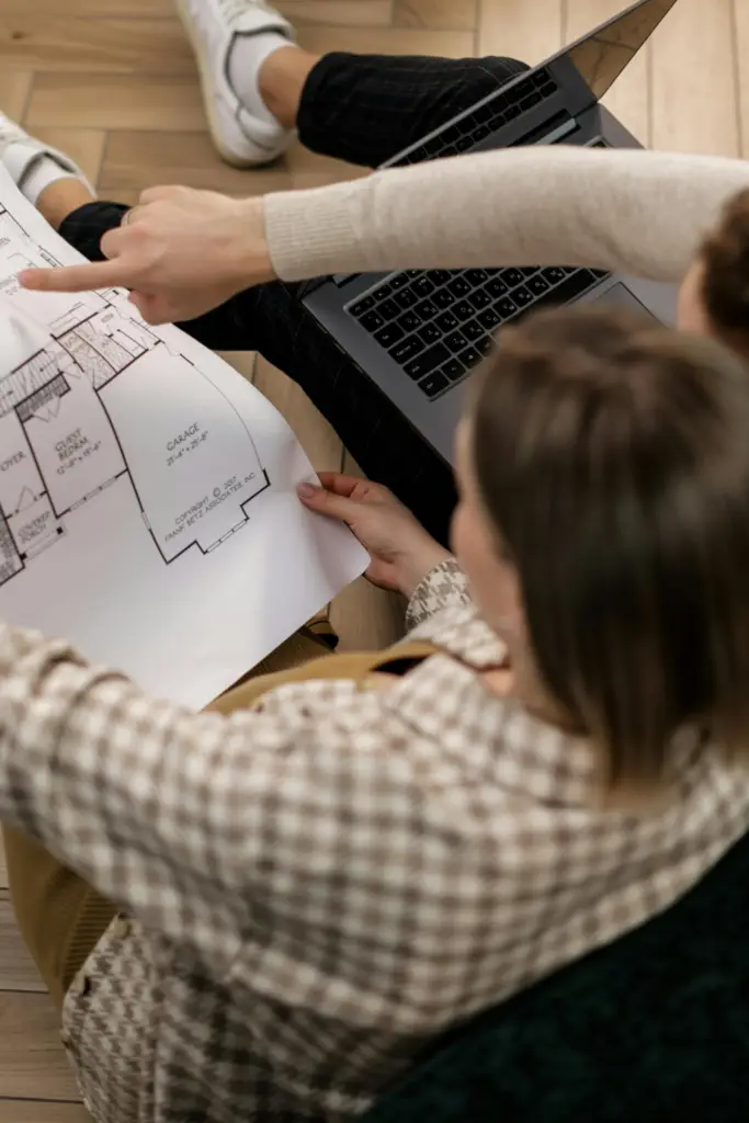 Couple analysant un plan d’aménagement intérieur avec une architecte d’intérieur dans les Weppes