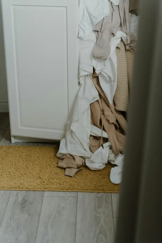 Dressing surchargé avec vêtements débordant par manque d’aménagement adapté