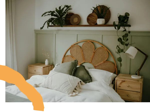 Chambre cosy avec soubassement vert et tête de lit en rotin après aménagement intérieur